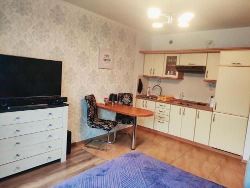 - une cuisine avec une table et une télévision dans la chambre dans l'établissement Apartament Klonowa, à Kołobrzeg