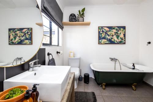 a bathroom with two sinks and a bath tub at No 1 Dicks Street Apartment in Howick