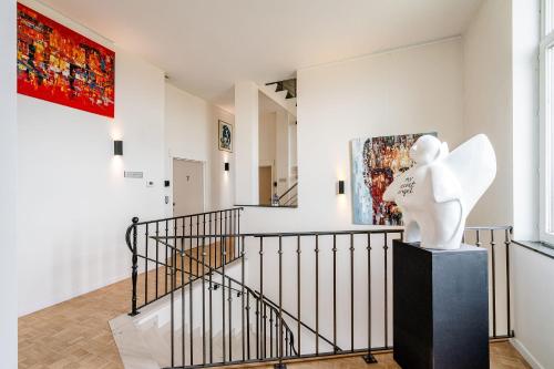 a staircase with a statue in the middle of a room at Hotel De Pupiter in Kluisbergen