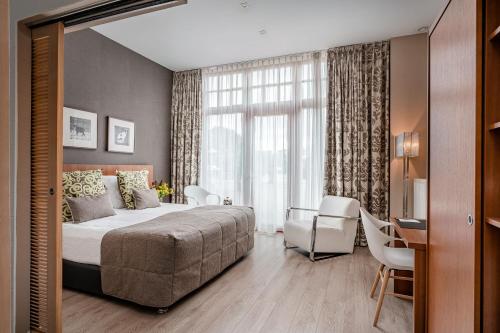 - une chambre avec un lit, un bureau et une fenêtre dans l'établissement Hotel De Pupiter, à Kluisbergen