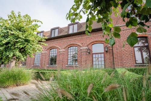 a large brick building with windows on it at Hotel De Pupiter in Kluisbergen