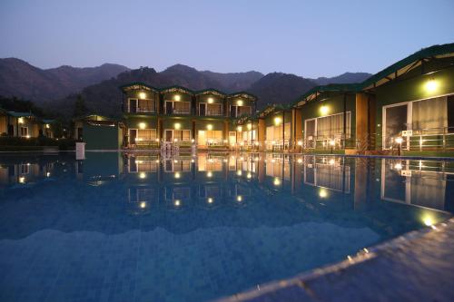 a hotel with a swimming pool at night at Camp Brook - Luxury Camping in Rishikesh in Rishīkesh