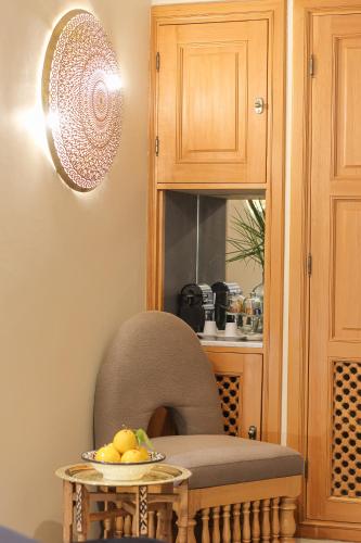 a chair and a table with a plate of fruit on it at Dar Lys Luxury Riad & Spa in Fès