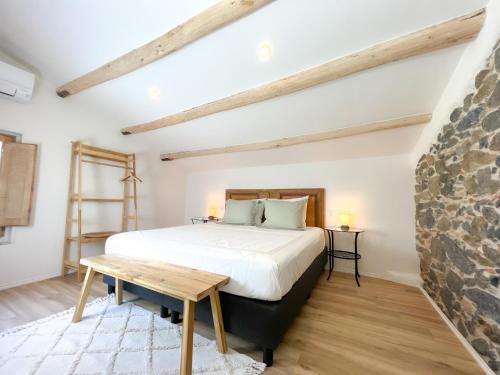 a bedroom with a large bed and a wooden table at Can Jan Vives in Vidreres