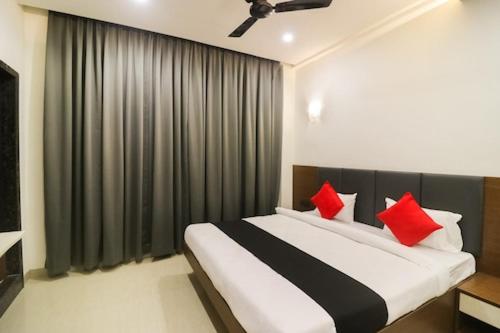 ein Schlafzimmer mit einem großen Bett mit roten Kissen in der Unterkunft Hotel Nikhil Regency in Bhilai