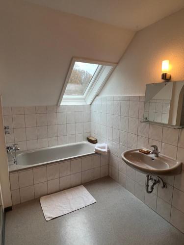ein Badezimmer mit einer Badewanne und einem Waschbecken in der Unterkunft Wald Panorama Appartement in Battenberg