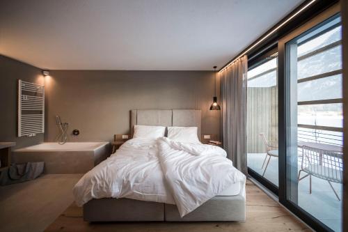 una camera con letto e vasca da bagno accanto a una finestra di OVINA`s HAUS a Sand in Taufers