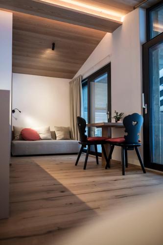 a living room with a table and chairs and a couch at OVINA`s HAUS in Sand in Taufers