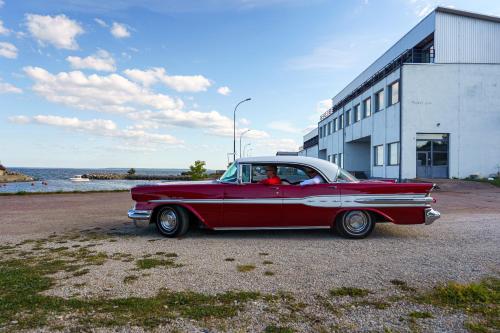 an old red car parked in front of a building at Viinistu Art Hotel in Viinistu