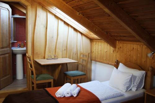a bedroom with a bed and a table and a sink at Tiszafa Vendégház Szentgál in Szentgál