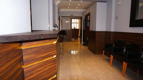a bar in a room with chairs and a hallway at Crestfield Hotel in London