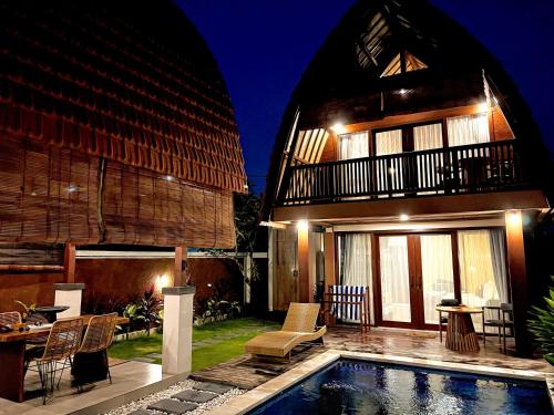 a house with a swimming pool in front of a house at Bhumi Lovina Residence & Villa in Singaraja