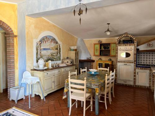 a kitchen with a table and chairs in a room at Orosei RE - Villa Samuela a 50 m dal mare in Orosei