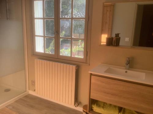 une salle de bain avec un lavabo et une fenêtre dans l'établissement Le chant de la sorgue, à LʼIsle-sur-la-Sorgue
