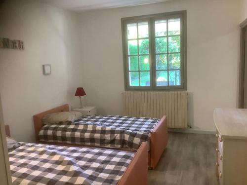 2 Betten in einem Zimmer mit Fenster in der Unterkunft Le chant de la sorgue in LʼIsle-sur-la-Sorgue