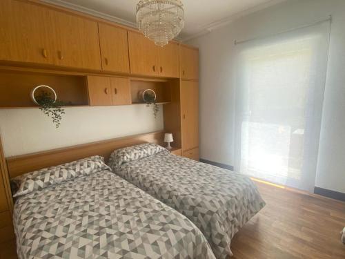 a bedroom with two beds and a chandelier at Bajo con terraza a 5 min de la playa (3 hab-6 per) in Santander