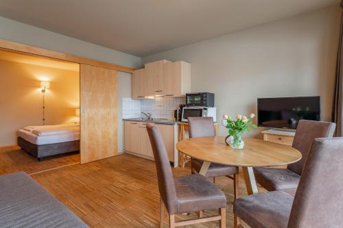 a room with a table and a kitchen with a bed at Ski Dome Apartments-Apartment VIVA & Heaven Holiday Chalet in Kaprun