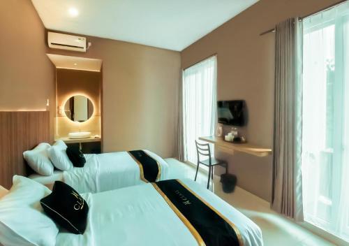 ein Hotelzimmer mit 2 Betten und einem Schreibtisch in der Unterkunft Class Premium Guest House in Kasri