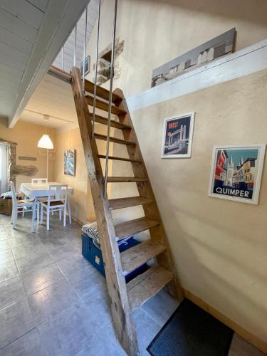 a wooden staircase in a room with a table at Authentique Penty au coeur du bourg in Roscanvel