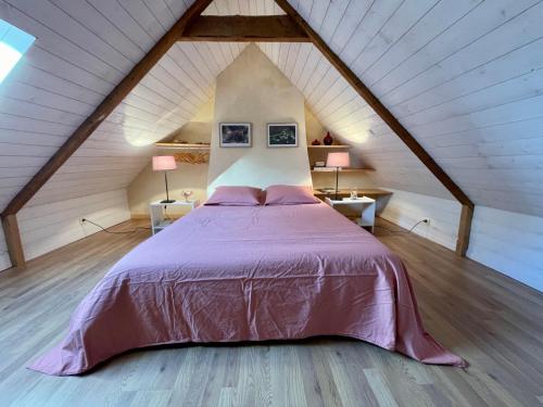 ein Schlafzimmer mit einem großen Bett im Dachgeschoss in der Unterkunft Authentique Penty au coeur du bourg in Roscanvel