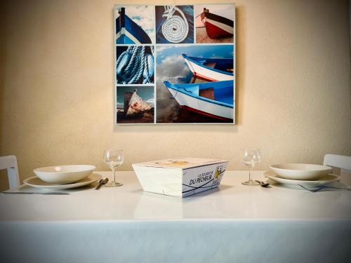 a table with two bowls and a box and glasses at Authentique Penty au coeur du bourg in Roscanvel