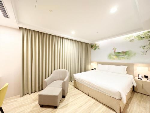 a hotel room with a bed and a chair at 台南星鑽國際商旅 Hua Hotel in Tainan
