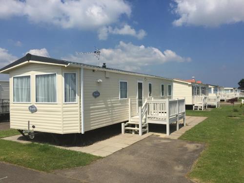 a white mobile home parked in a parking lot at Summer Dreams Holiday Home in Skegness