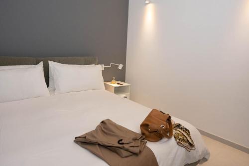 una cama blanca con una bolsa marrón sentada en ella en Rosselli 74 by Arbaspàa en La Spezia