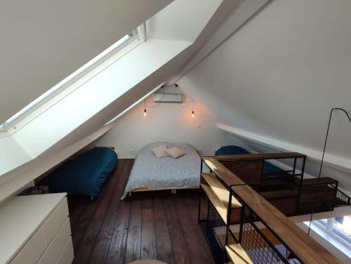 a attic room with a bed and a staircase at La petite Madeleine Paisible - Contemporain - 2Ch in La Madeleine