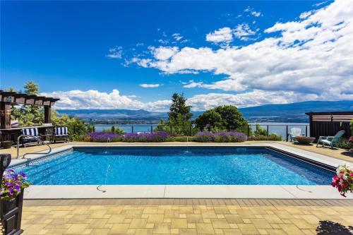 a swimming pool with a view of the water at Stunning Lake View w Private Hot tub, Pool -snl & Outdoor Kitchen 2400sqft in West Kelowna