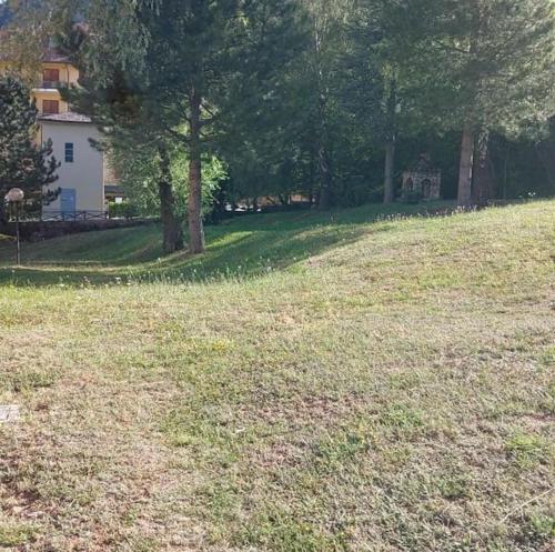 un campo de césped con árboles y una casa en Appartamento Residence Monte D'Ocre en Rocca di Cambio