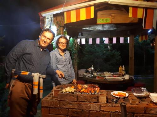 a man and woman standing next to a table with food at Heidi Korea in Hongcheon