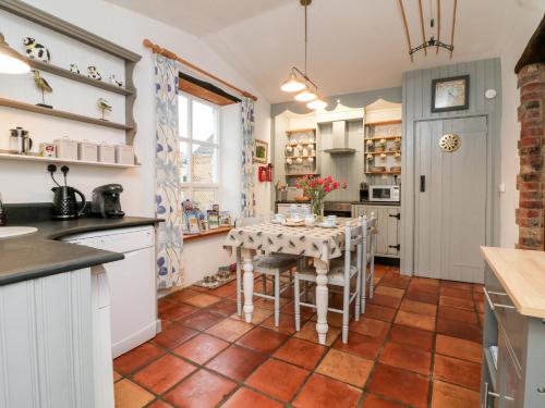 a kitchen with a table and chairs in a room at The Shippen in Bude