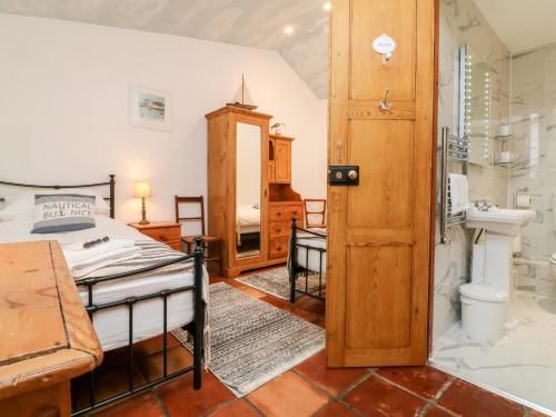 a bedroom with a bed and a bathroom with a shower at The Shippen in Bude