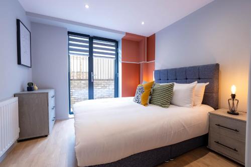 a bedroom with a large bed and a large window at Luxurious Apartments Hackney near Train Station in London