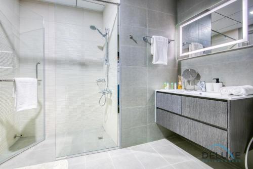 a bathroom with a glass shower and a sink at Vibrant 1BR in Bella Rose Al Barsha South by Deluxe Holiday Homes in Dubai