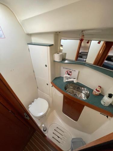 Precioso velero en Badalona de 3 camarotes في بادالونا: حمام صغير مع مرحاض ومغسلة