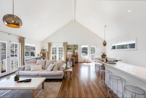 a white living room with a couch and a table at Cumberland House in Katoomba
