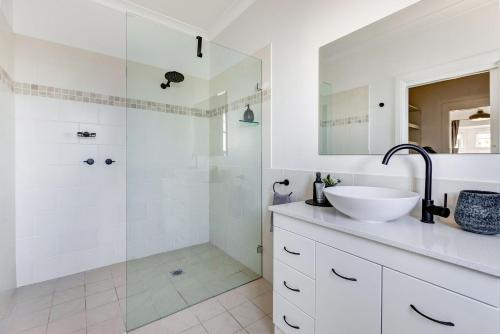 a white bathroom with a sink and a shower at Cumberland House in Katoomba