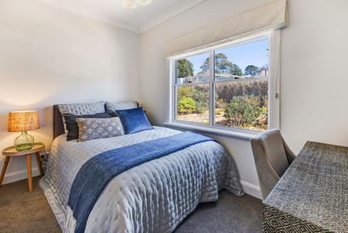 a bedroom with a bed and a large window at Cumberland House in Katoomba