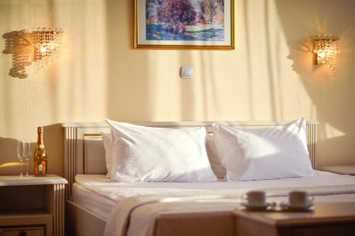 a bedroom with a bed with white sheets and pillows at Готель Дніпро in Kyiv