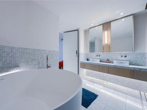 a white bathroom with two sinks and a tub at Pyrmont Town House Homestay in Sydney