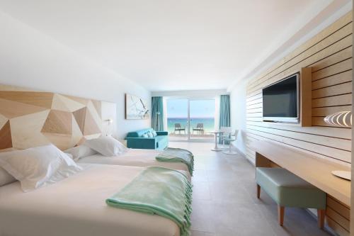 um quarto de hotel com duas camas e uma secretária em Iberostar Selection Playa de Palma em Playa de Palma