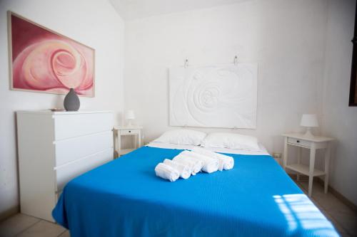 Una cama azul con toallas encima. en Pietre Bianche, en Carovigno