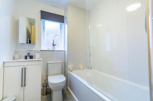 a bathroom with a toilet and a tub and a sink at K Suites - Goldcrest Road in Nottingham