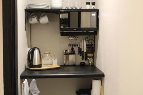 eine Küche mit einem schwarzen Regal und einer Mikrowelle in der Unterkunft 9 Serendipity Stay in George