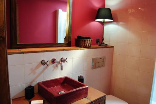 baño con lavabo rojo y espejo en Cal Porxo del Priorat, en Pradell