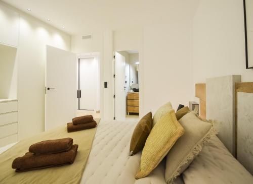 ein weißes Schlafzimmer mit einem großen Bett mit Kissen in der Unterkunft 136 Luxury Sea View - Alicante Holiday in La Mata