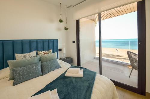 a bedroom with a bed with a view of the beach at 136 Luxury Sea View - Alicante Holiday in La Mata