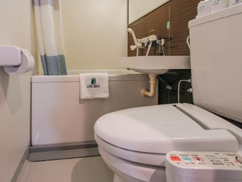 Łazienka z białą toaletą i umywalką w obiekcie HOTEL LiVEMAX Umeda Doyama w Osace